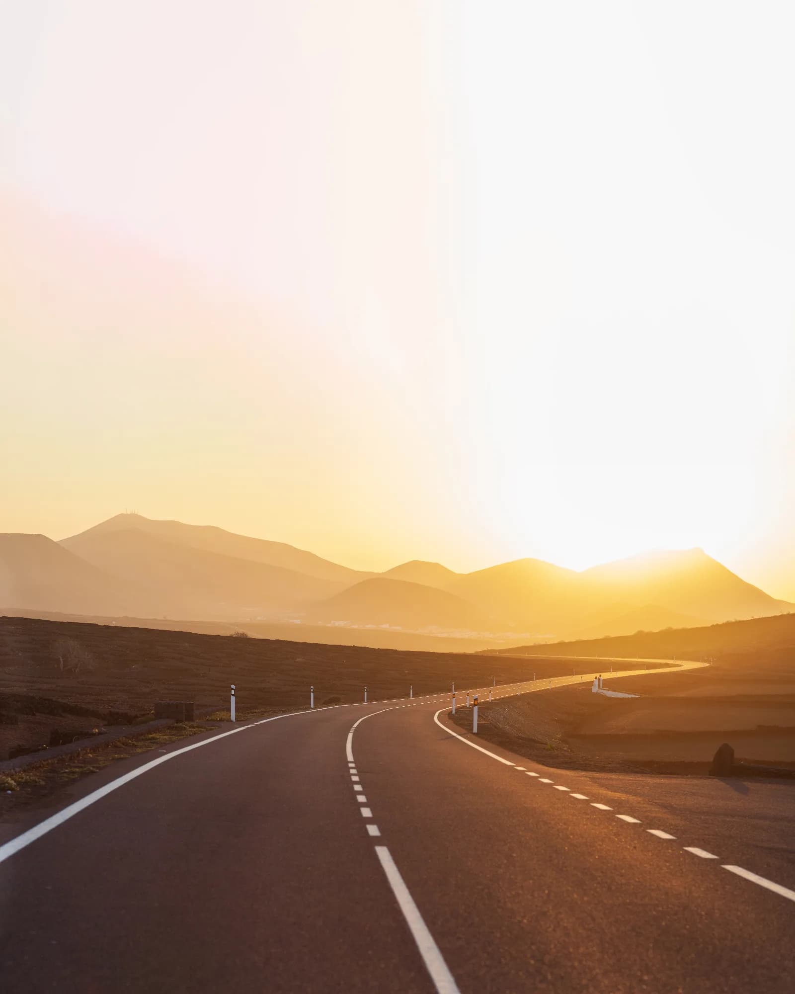 Ruta asfaltada que atraviesa un paisaje rural al atardecer